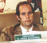 Man seated at a desk with a nameplate reading "Commissioner W. Andrew Beckstoffer.